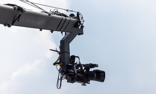 Video camera on crane with blue sky background, TV camera on a crane live event video.